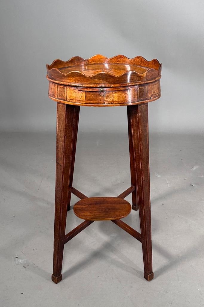English George III Mahogany Kettle Stand: English George III Mahogany Kettle Stand, oval top with scalloped gallery, centered by an oval fan shaped reserve, with a candle slide, raised onb squared splay legs joined by an oval stretcher shelf.