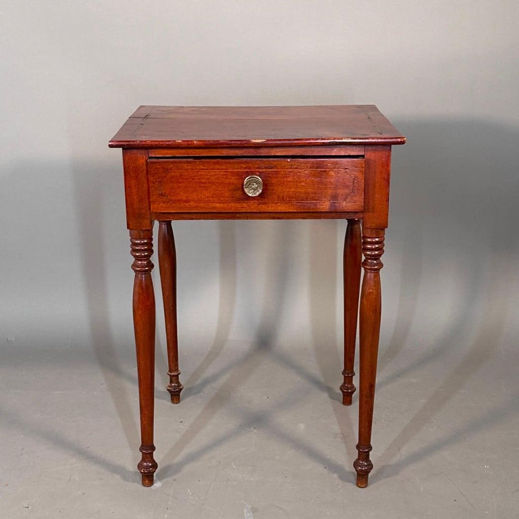 American Cherry Inlaid One Drawer Stand, 19thc.: Squared top with inlaid border and fans at the four corners, over a single drawer with an eagle and shield brass pull, raised on graceful turned legs. Dimensions: 26 x 19.5 x 16.5 in. Condition: Refin