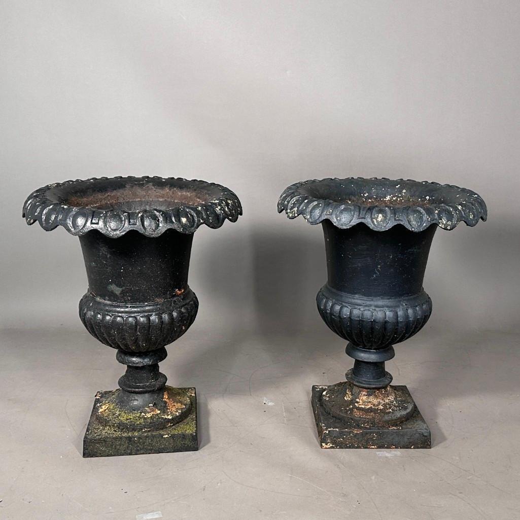 Large Pair of Antique Black Painted Cast Iron Planters: Large Pair of Antique Black Painted Cast Iron Planters, probably 19thc., of campana form with scalloped rims raised on gadrooned pedestals and squared bases. Dimensions: 25 in.h. x 19.5 in. dia.