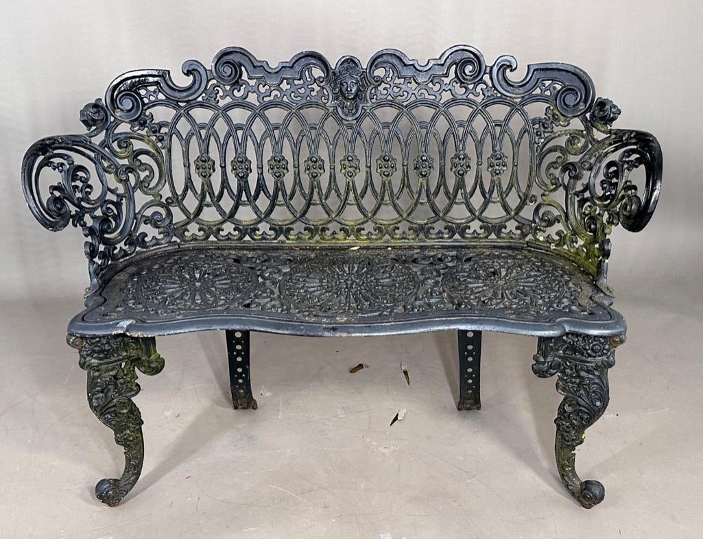 Victorian Cast Iron Garden Bench: Victorian Cast Iron Garden Bench, elaborate openwork scroll designs centering a female mask, raised on cabriole legs. Dimensions: 33 in.h. x 45 in.w. 15 in.d. Condition: Uneven finish. Accumulated out