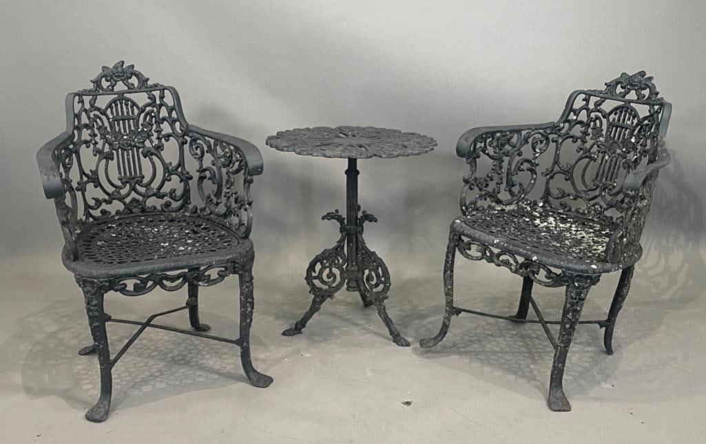 Pair of Victorian Cast Iron Garden Arm Chairs and Table: Pair of Victorian Cast Iron Garden Chairs and Table, Robert Wood Foundry, Philadelphia, c.1860-90. Tub shaped chairs cast with lyre forms, foliate scrolls and swags, on shaped feet, together with a gr