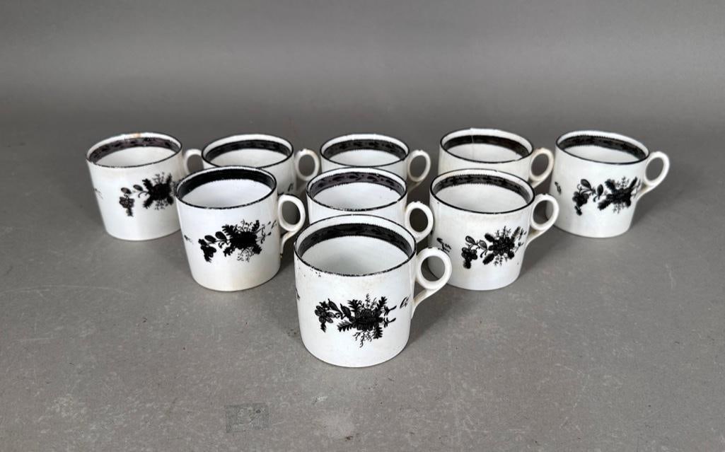 Newhall Porcelain Coffee Cans, ca. 19th century.: White porcelain coffee cans with hand painted decorations in black, with loop oval handles, unmarked, each apprx 2-3/8"T. Nine total Condition: several with small chips at the bottom edges.