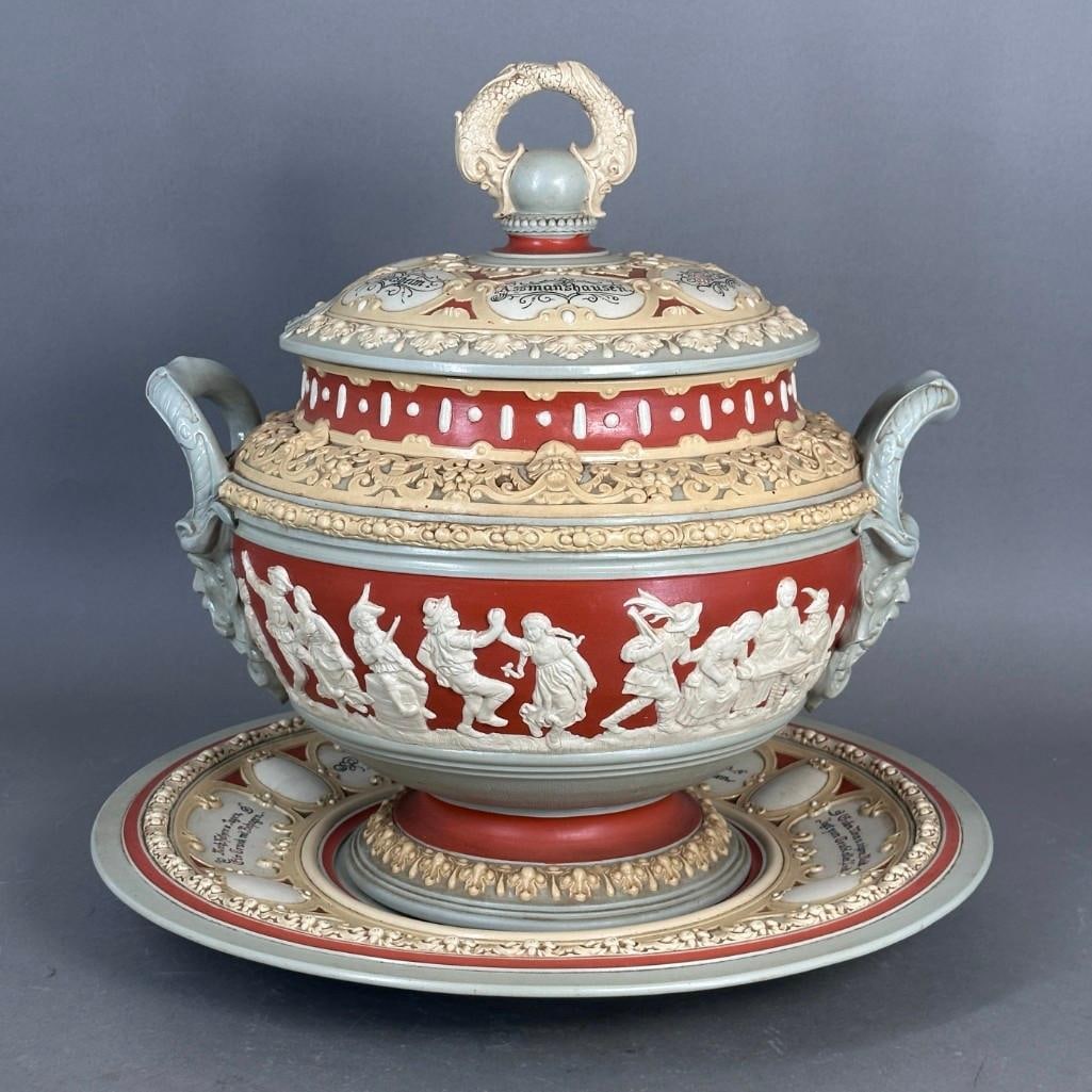 Mettlach Stoneware Punch Bowl, Cover and Stand: Mettlach Stoneware Punch Bowl, Cover and Stand, the shouldered bowl form with leaf man mask handles, the body decorated with figures making merry and dancing, on a fitted stand inscribed in German wit