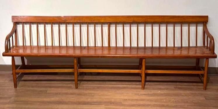 American Mixed Woods Windsor Style Bench, 19th century: A large antique American mixed woods Windsor style bench, 19th c., having a flat crest rail with tapered spindles, shaped plank seat with scrolled arms, and turned splayed legs connected by stretchers