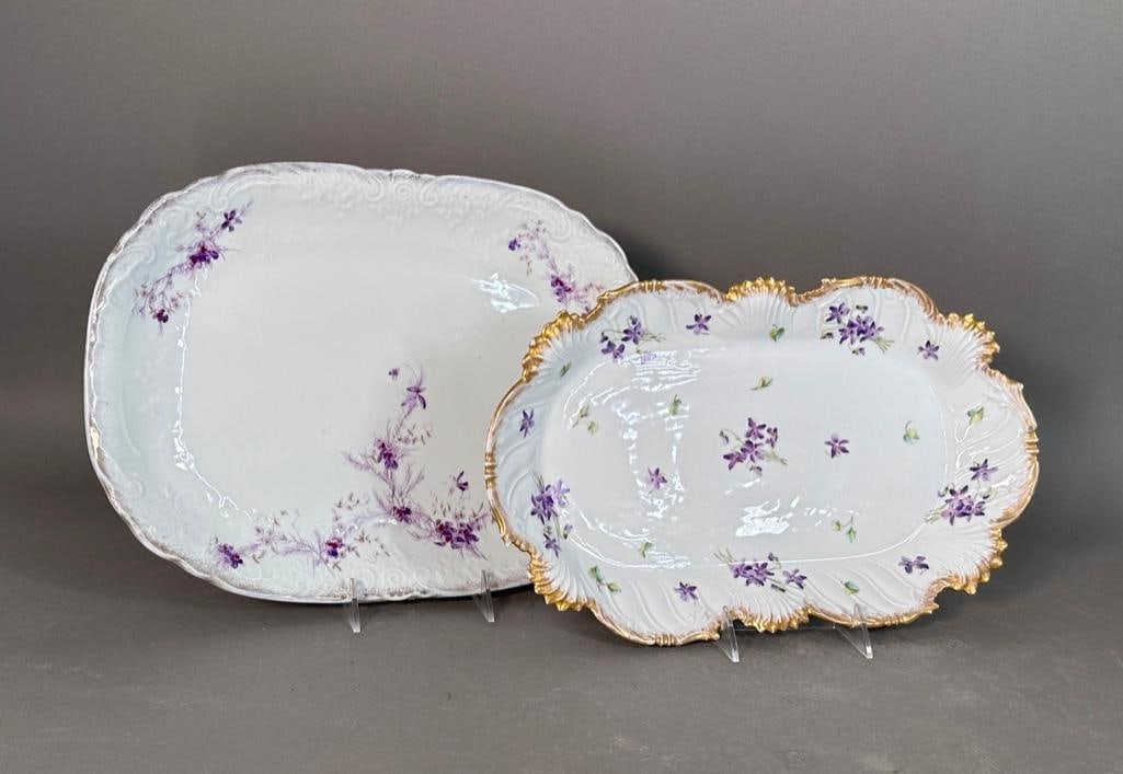 Two Antique Porcelain Platters: Purple flower themed platters, both antique and decorated with purple flowers and gilt rims; oblong platter with most of the gold rubbed off with relief decoration on edge with C scrolls and ferns