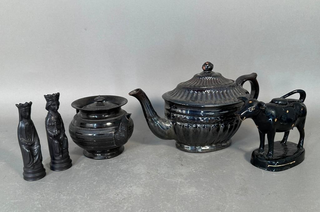 A Lot of Blackware Pottery: Black glazed cow cream pitcher, 5"H x 7"L, one ear repaired, overall black glaze with applied yellow dots, unmarked; Two Wedgwood figures, King and Queen, both 5"H, with Wedgwood stamps
