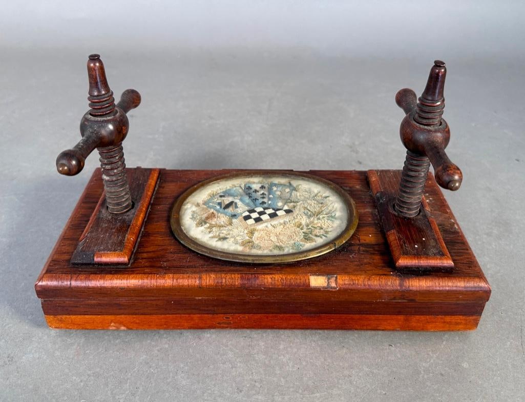 Antique Flower Press, European 19th century: Wood press with two rectangular plates to be pressed together by means of the wooden screws left and right. The top is adorned with a embroidery panel with cards and flowers. 9.5"L x 4.5"W,
