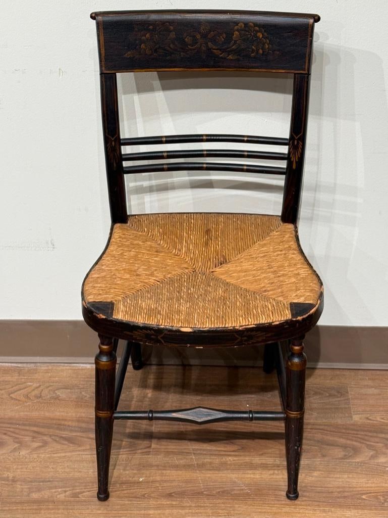 Vintage Hitchcock Style Rush Seat Chair: Dining chair, painted black with polychrome stencil pattern, wove rush seat, 33.5"H x 19"W x 17.5"D. Condition: wear to paint, good.