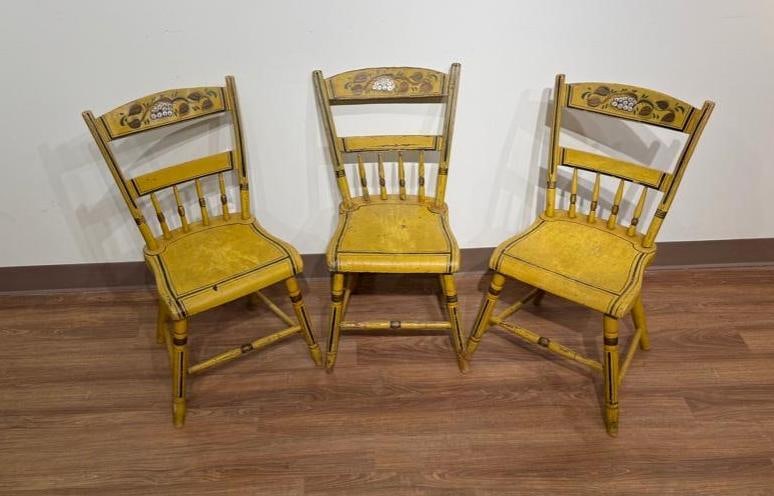 Three Country Windsor Chairs, ca. 1840: Original yellow paint with hand stenciled painting on crest rail, with black painted trim, plank seats. Apprx 31 x 17 x 19 in. Condition: significant wear including scuffs and fading, with age and use
