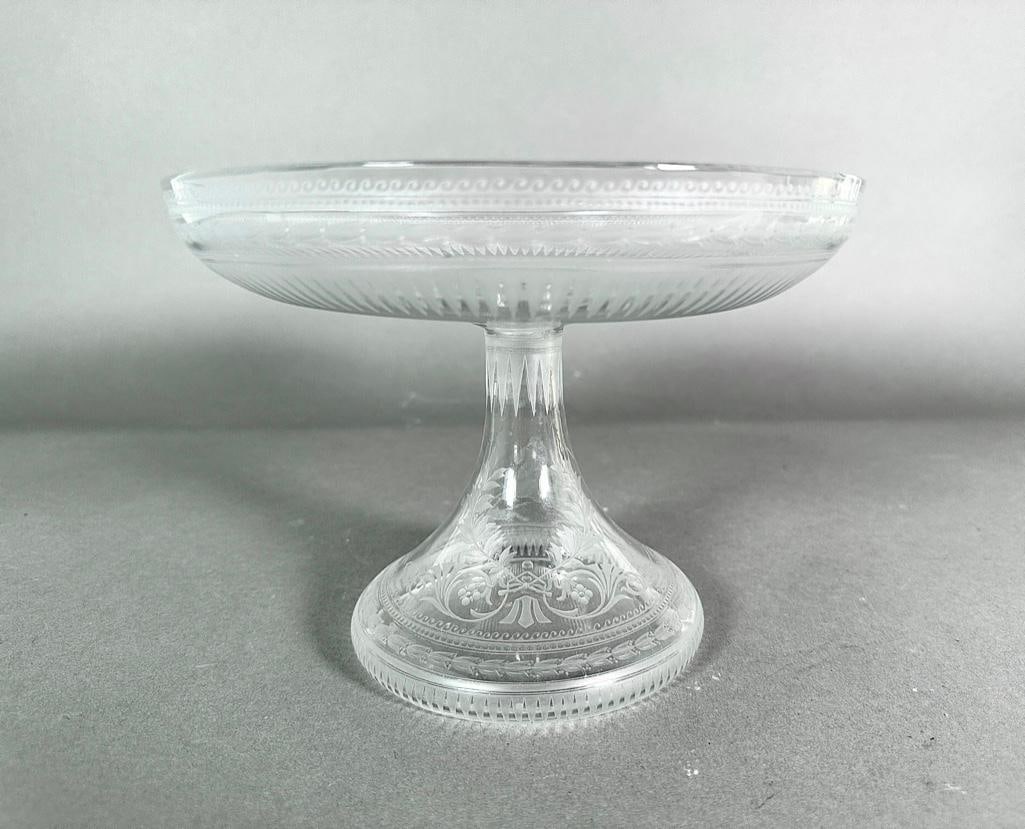19th Century Glass Tazza: Neo-classical period, Continental, 19th century. Clear glass dish on bottled shaped base which is engraved with a huntress on horseback with dog. Other engraved borders of waves, lappets and leaf-chai