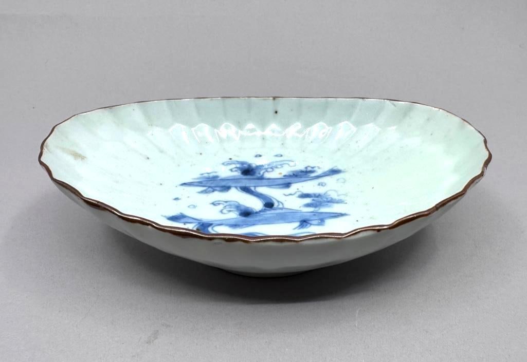 Japanese Hirado Porcelain Dish: Japanese Hirado Porcelain Dish, probably late 19th-early 20th century in date, is oval with molded floral motifs on sides. A pair of fishes, painted in cobalt blue, swim in the center of the dish.