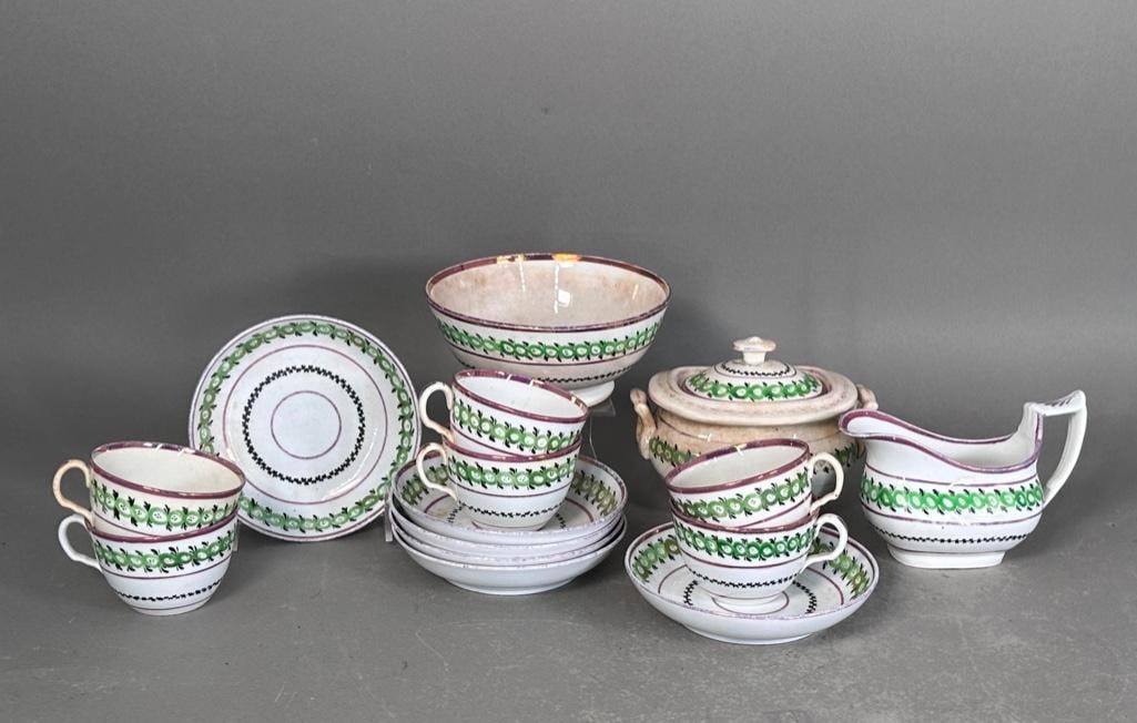 Antique English Lusterware Partial Tea Service: Group of six handled cups and saucers, with covered sugar, cream pitcher and waste bowl. The teapot is missing from set. Hand decorated in green, black and pink luster accents and rims. Unmarked soft