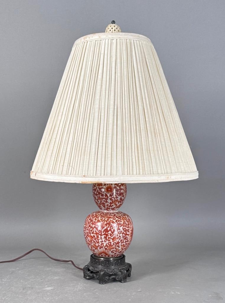 Antique Double Gourd Porcelain Lamp: Iron-stone red double gourd table lamp, with shade, two lights with only one pull chain, electrified, on fern leaf metal base, carved bone finial, appx 21"T. Condition: Only one pull chain.
