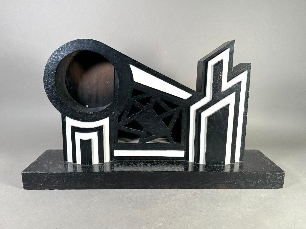 Art Deco Painted Wood Clock Case: Art Deco Painted Wood Clock Case, wood construction to simulate a stylized modernistic city skyline, painted in black and white, with circular opening for clock case. Dimensions: 14 x 24 x 6 in.