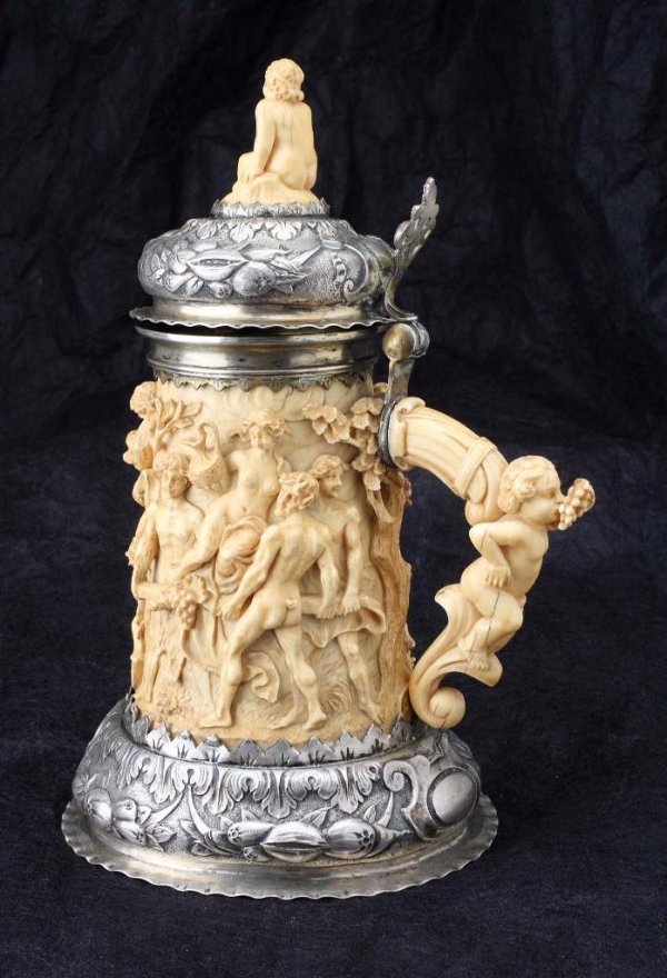 German Silver and Ivory Tankard late 17th c.: A late 17th - early 18th c. German silver and ivory tankard. The ivory body deep carved with a mythological scene. The scroliate silver base bears the town mark (two crossed swords) and the maker's ma