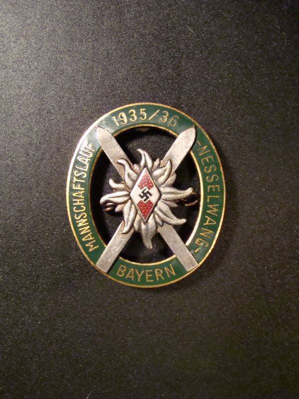 Hitler Youth Ski Competition Badge 1935-36.: Hitler Youth Ski Competition Badge. Multi piece construction The outer border reads Mannschaftslauf 1935-36-Nesselwang-Bayern with perfect green enamel. The silver plated skis are attached with 4 holl
