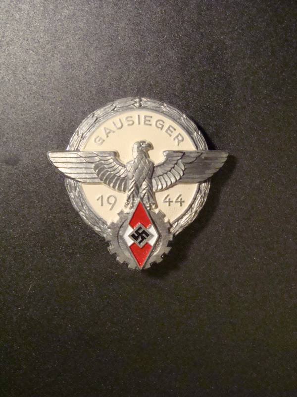 German WWII Hitler Youth 1944 Gausieger Badge.: Hitler Youth Gausieger 1944 Award Badge. Scarce 1944 pattern Hitler Youth Gausieger badge. Maker marked to reverse as follows G Brehmer Markneukirchen and has a counter sunk hinge and hook fixing. The