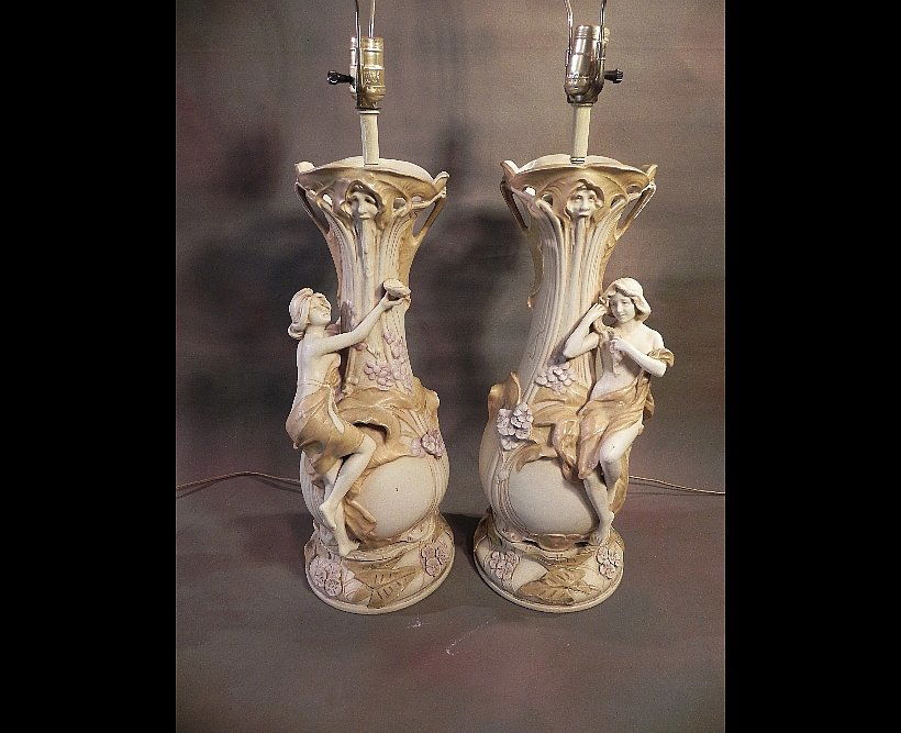 Pair of Art Nouveau Amphora Lamps: A lovely pair of vases converted into lamps. The bases were created specifically for that conversion. Both lamps work. We did not take these apart to look for marks. There is some restoration work on