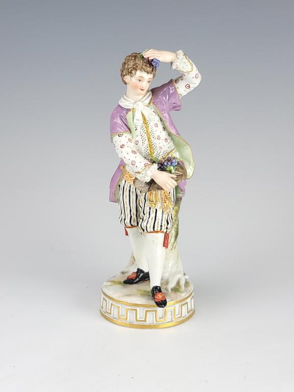 19C German Meissen Porcelain Figurine: 19C Antique German Meissen Porcelain Figurine of young gentlemen carrying the grapes. Height 6 1/2" ( 16,5 cm ), width 2 3/8" ( 6 cm ). Marked on underside.Condition very good, small ships on leaves. 