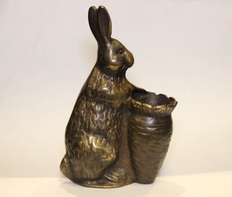 bronze sculpture of a rabbit holding a basket