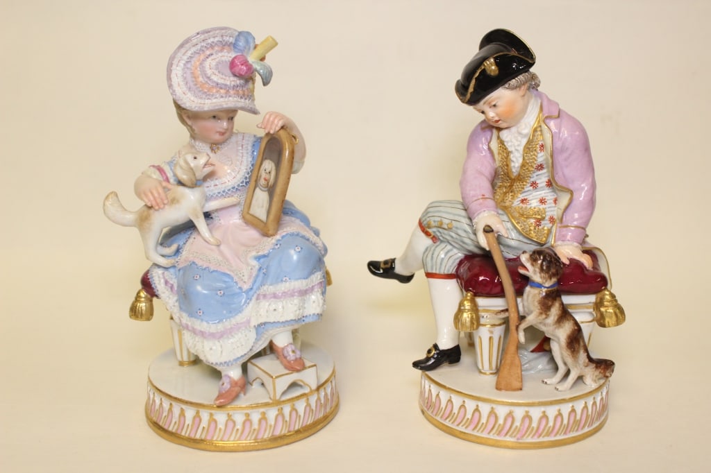 Meissen Pair Figures Boy and Girl with Gun Dog: Dimension: 5 1/2" Height. Modelled as a huntsman seated on a stool holding a gun, with a dog at his feet, on a circular plinth base. his female companion similarly modelled seated on a stool holding h