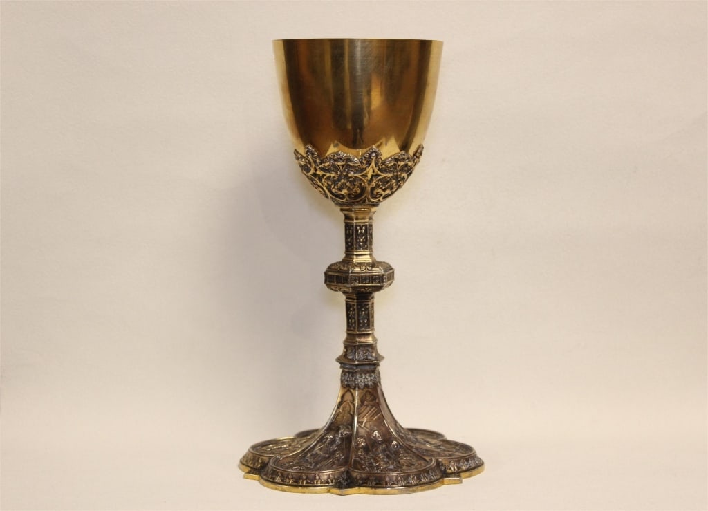 antique liturgical chalice in the Gothic Revival s: antique liturgical chalice in the Gothic Revival style. It is a sacred vessel primarily used for holding consecrated wine during Christian religious ceremonies, such as the Holy Eucharist or Mass.Dime