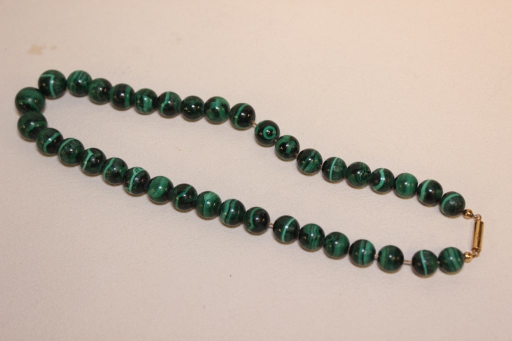 Malachite Beaded Necklace: Dimension: 1cm w each beadThe necklace is composed of numerous spherical beads made of natural malachite. Malachite is a vibrant green mineral known for its characteristic dark green to black banding