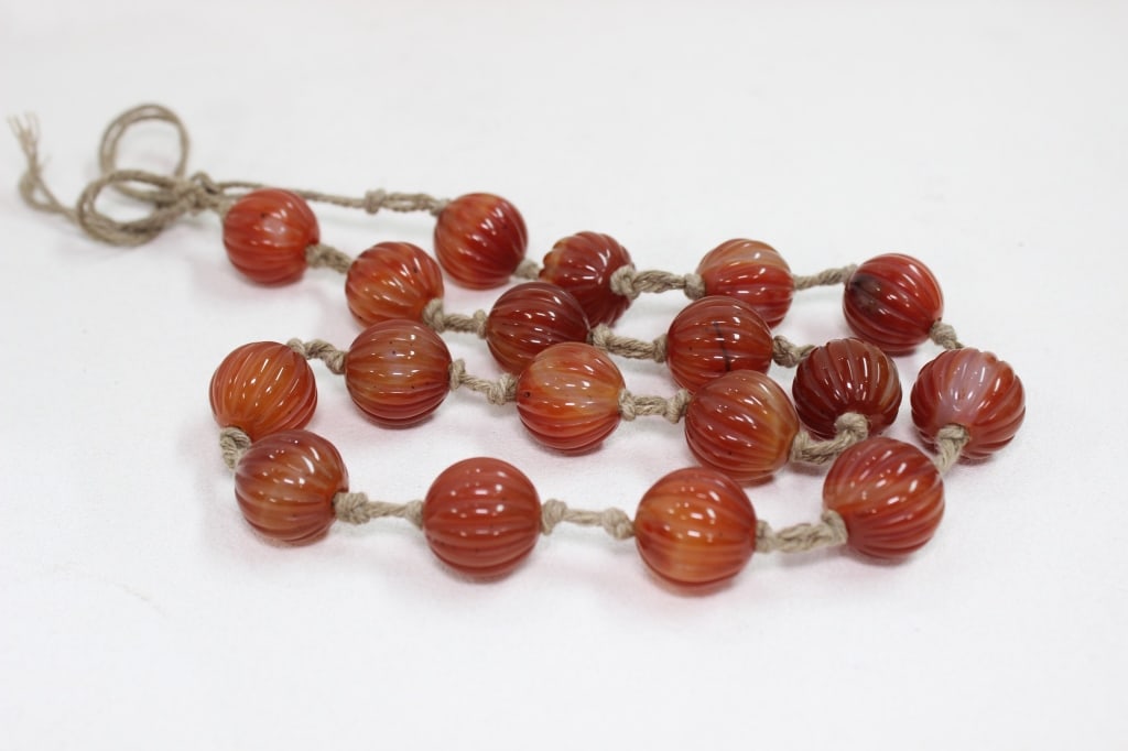 a strand of carved carnelian agate beads: a strand of carved carnelian agate beads. They appear to be antique or vintage, possibly of Chinese or Tibetan origin, known as "melon beads" due to their fluted, globular shapeDimension: 2cm w each T