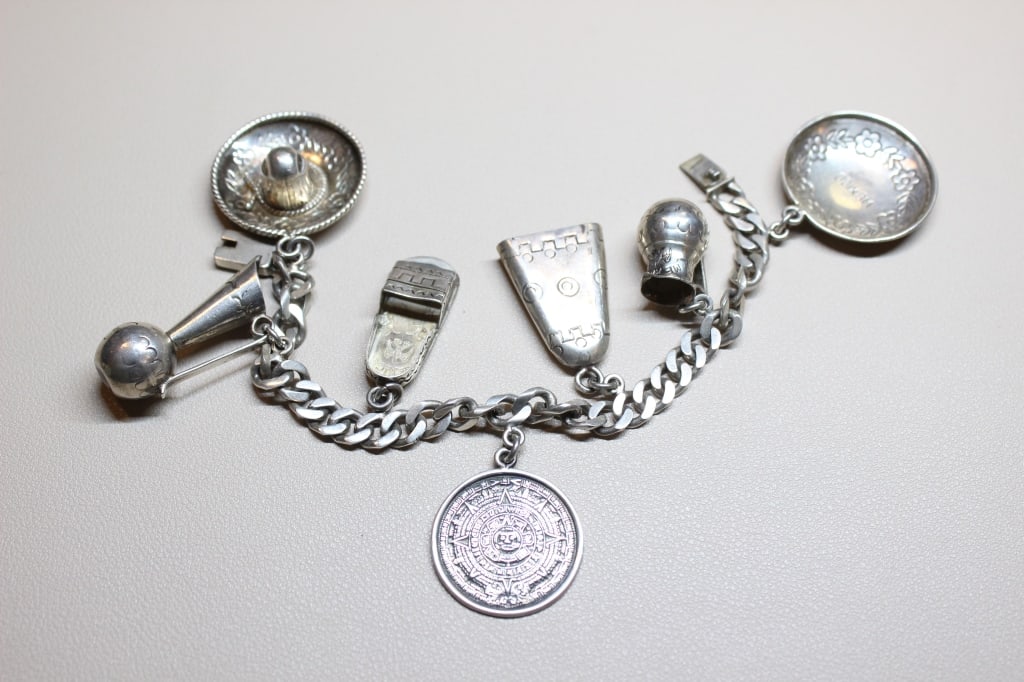 Vintage Mexican Sterling Silver Charm Bracelet,: Dimension:7 1/4"L These bracelets typically feature several oversized, three-dimensional charms representing Mexican culture and iconic symbols. The bracelet features a variety of detailed charms, whi