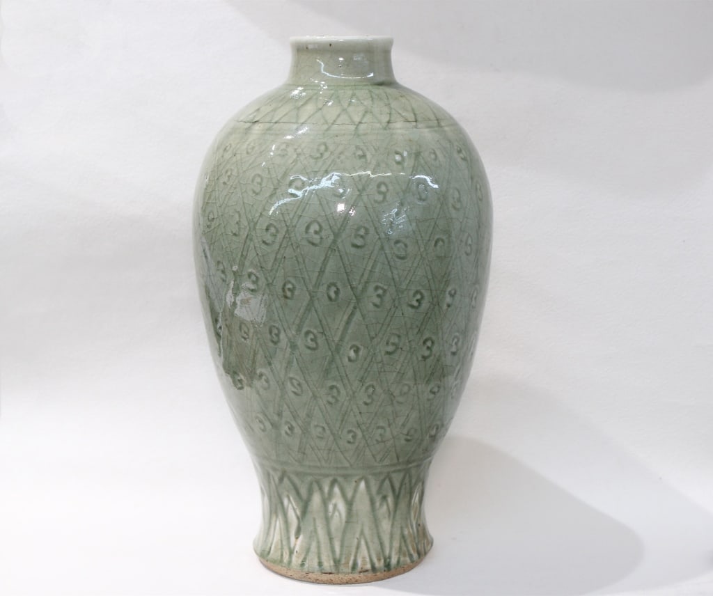 Chinese Celadon "Meiping" Porcelain Vase: The vase features a light, grayish-green celadon glaze, known for its smooth, luminous quality and the fine, natural crackle that often develops in the glaze over time.Dimension: 13"HIt has the tradit