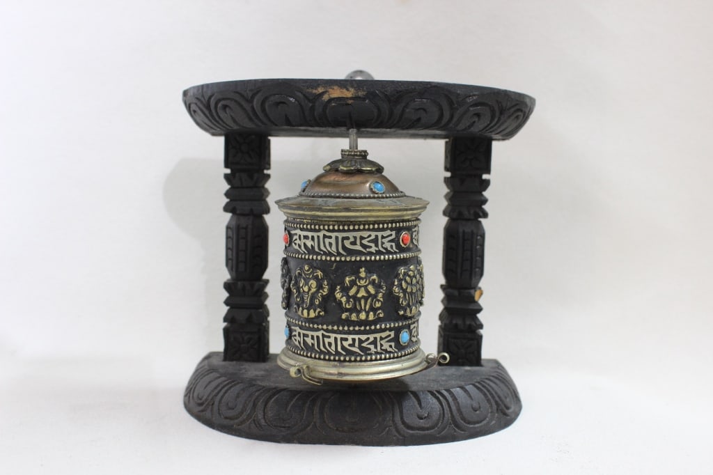 Tibetan Buddhist table prayer wheel: Tibetan Buddhist table prayer wheel, also known as a mani khorlo or mani wheel. This spiritual tool is used in Tibetan Buddhist practice as an aid for meditation and to accumulate wisdom and positive