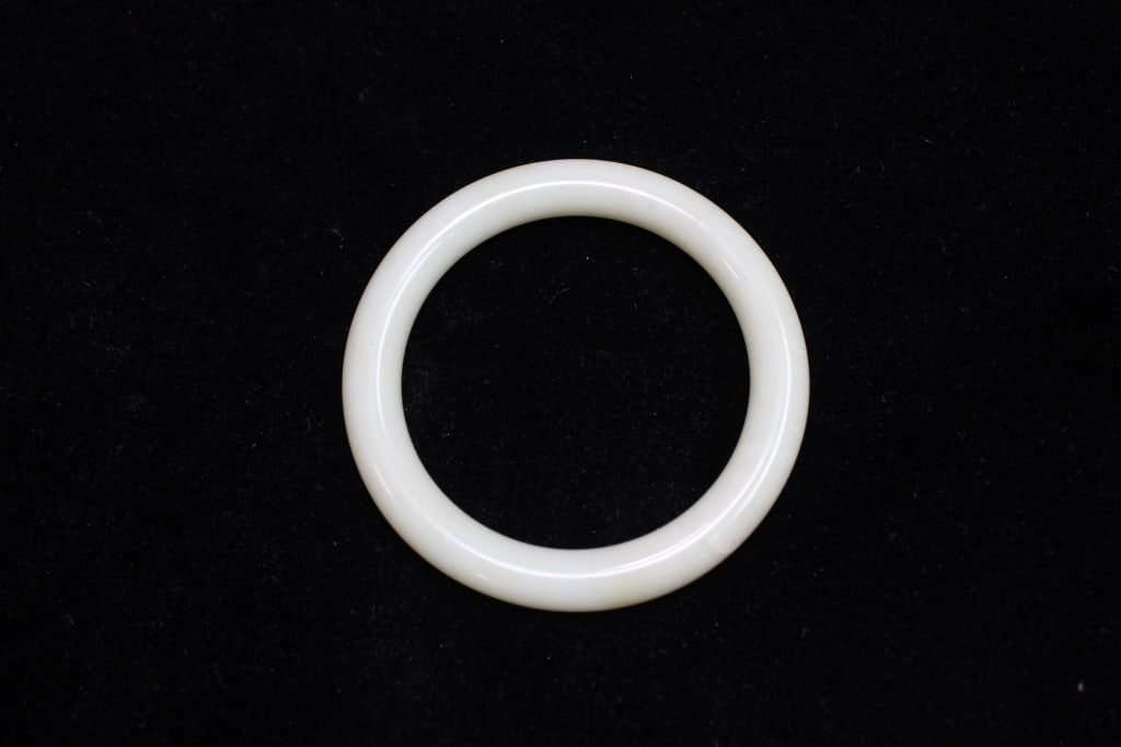 Chinese jade bangle bracelet: Dimension: 8cm w Chinese jade bangle bracelet. It is a smooth, circular, rigid bangle carved from a single piece of light celadon or white nephrite jade. The color is a pale greenish-white or creamy w