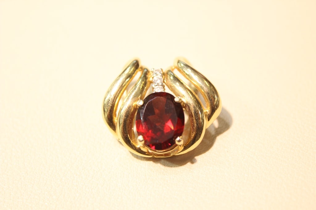 Vintage Garnet and Diamond Gold Accents Pendant: This specific design often features a large oval-cut garnet center stone accented by small diamonds and set in a yellow gold band. Dimension: 2.2cm x 2.5cm . 7.45gram