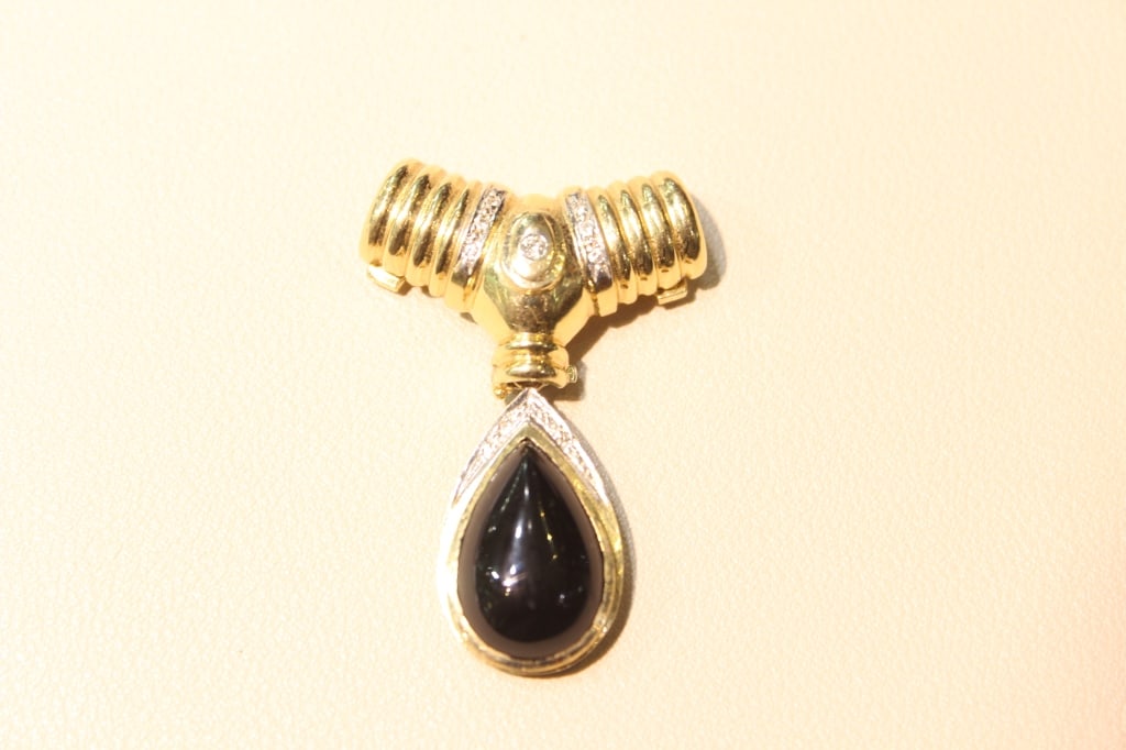 Vintage 14k Yellow Gold and Black Onyx Slide Penda: Dimension: 12gram. 3cmx 4.5cm.Features a large, pear-cut or teardrop-shaped natural black onyx cabochon. The yellow gold setting typically includes a ribbed or "puffed" figure "X" slide mechanism, whi