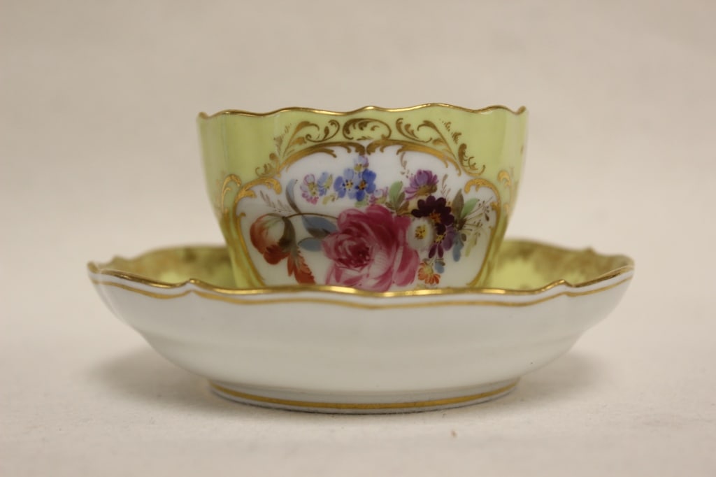 antique Meissen porcelain teacup and saucer set: Dimension: 4"W plate. This set features the Neuzierat (New Ornament) pattern. First designed in 1764 by Friedrich Elias Meyer, it is characterized by its elegant, curved shape and rocaille relief