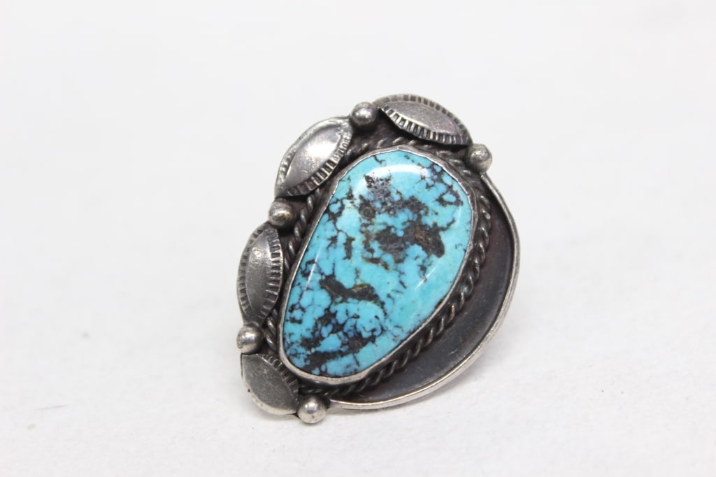 Vintage Classic Navajo ring of Southwestern Native: The ring features a large natural turquoise cabochon with a prominent dark matrix. The deep blue hue and "chocolate brown" or black webbed matrix are characteristic of highly collectible stones