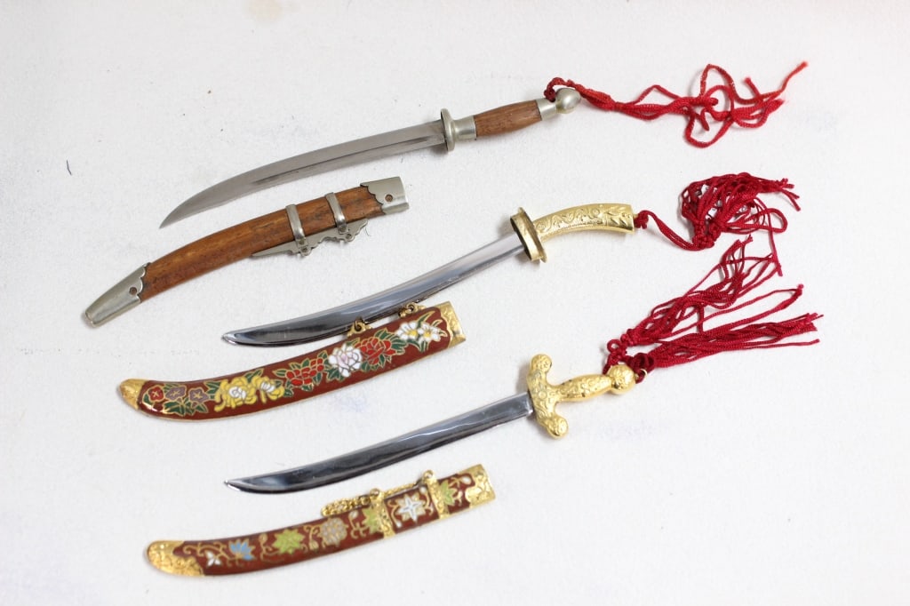 Vintage Chinese-style Decorative letter opener: vintage Chinese-style decorative letter opener , presented as collectible sets in ornate boxes. Three curved daggers in matching ornate sheaths. Two complete with red tassels and the metalwork 