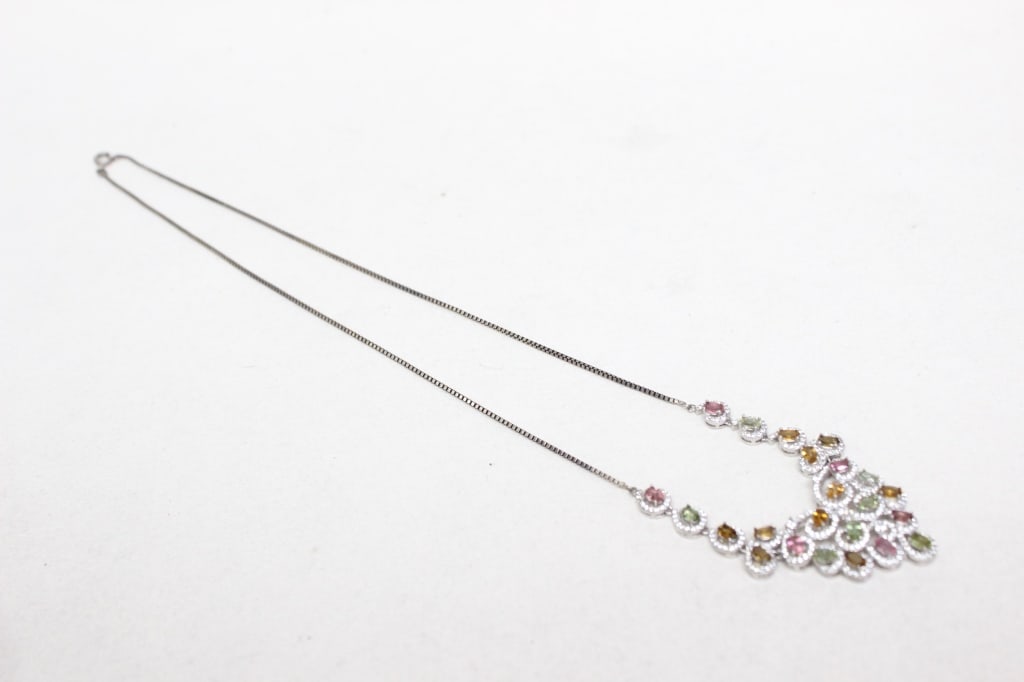 multi-color gemstone statement necklace: The necklace features a variety of oval-cut natural gemstones in vibrant shades. 11"L