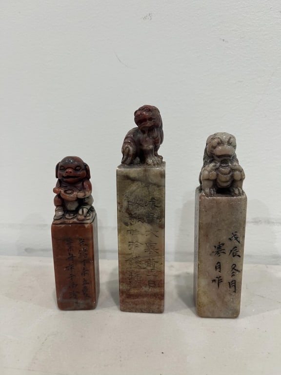 Three Chinese Soapstone Carved Seals: Three Chinese Soapstone Carved Seals . Each seal is topped with a hand-carved guardian lion (Foo Dog), a common motif representing protection and authority. The vertical faces are engraved with