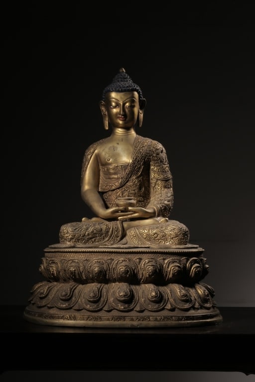 Chinese Gilt-bronze Sculpture of Shakyamuni Buddha: Dimension: 45.5cm H x 33.5 cm x 28.5cm. He is seated in the full lotus position (vajrasana) on a tiered, double-lotus pedestal.