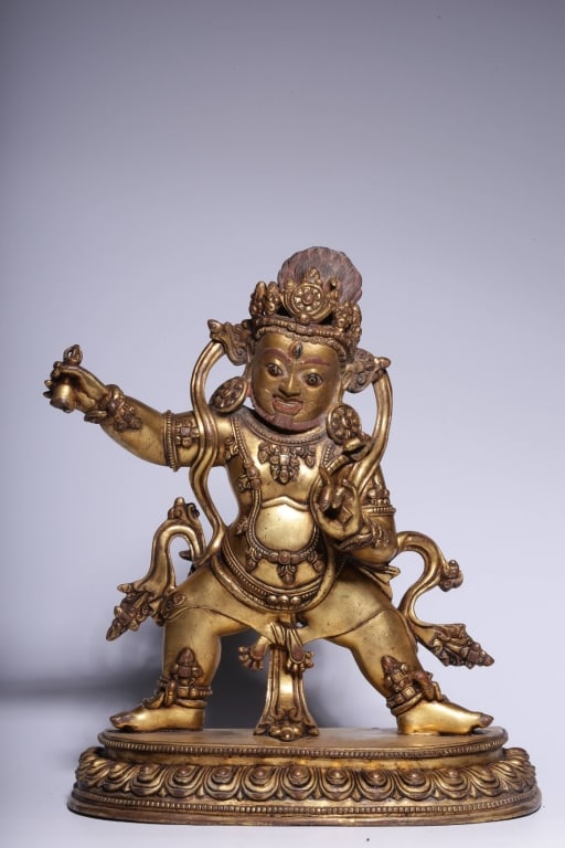 Chinese Gilt-bronze Figure of Vajrapani: Dimension : 25.5cm H x 22cm Lx 10.5cm,weight 3031gram. Vajrapani is depicted in the dynamic, aggressive warrior stance (pratyalidhasana), with his right leg bent and his left leg extended. He stands