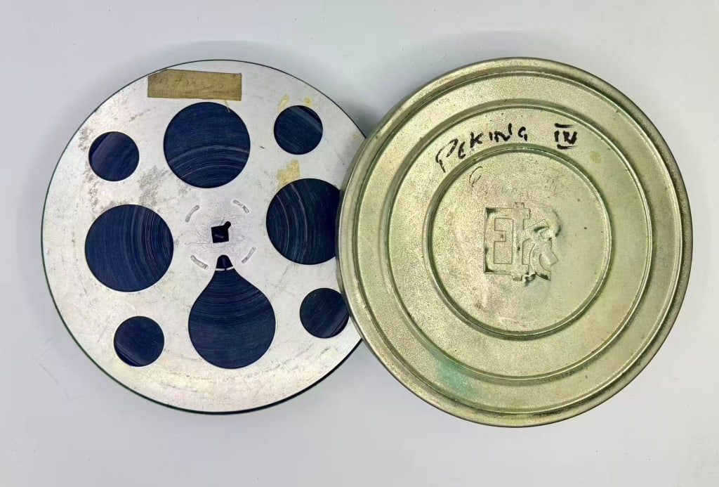 Vintage motion picture film reel and its protectiv: Vintage motion picture film reel and its protective metal canister. Stamped prominently into the center of the metal lid is a stylized Chinese character logo reading "?" (Y?ng)