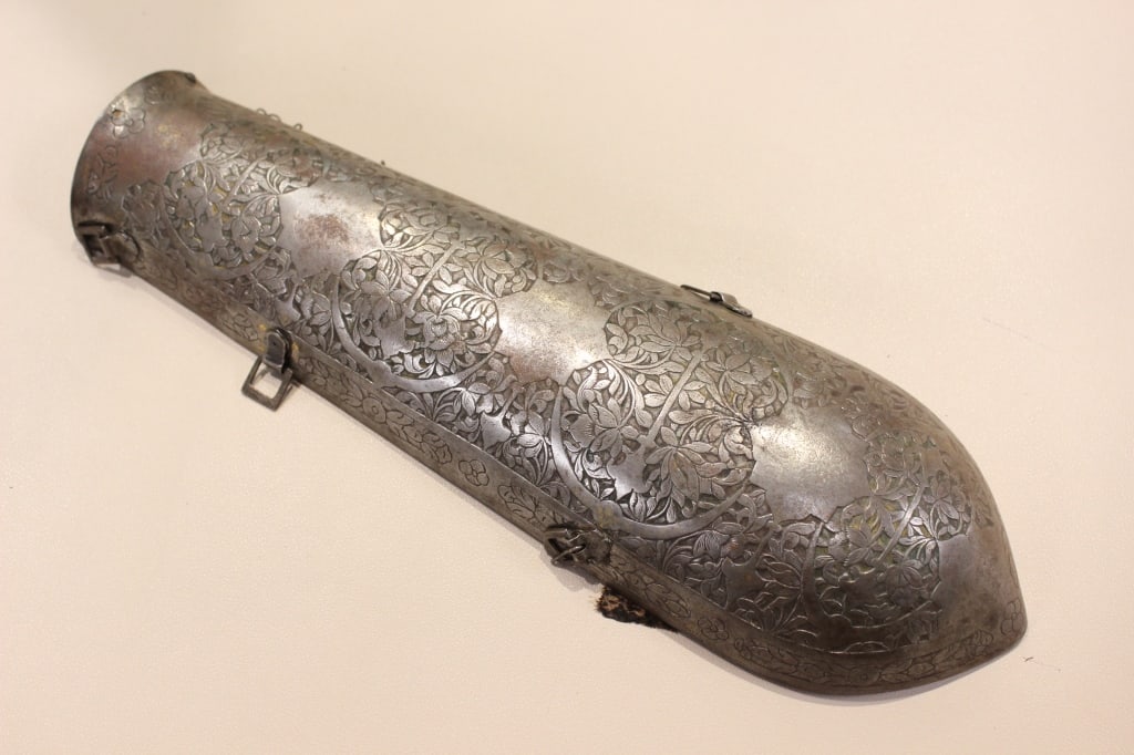 Antique Indo-Persian Bazu-Band: antique Indo-Persian Bazu-Band, a type of forearm guard used as part of traditional armor. Dimension: 13"inch Long. The surface features dense arabesque floral patterns and stylized medallions. Some