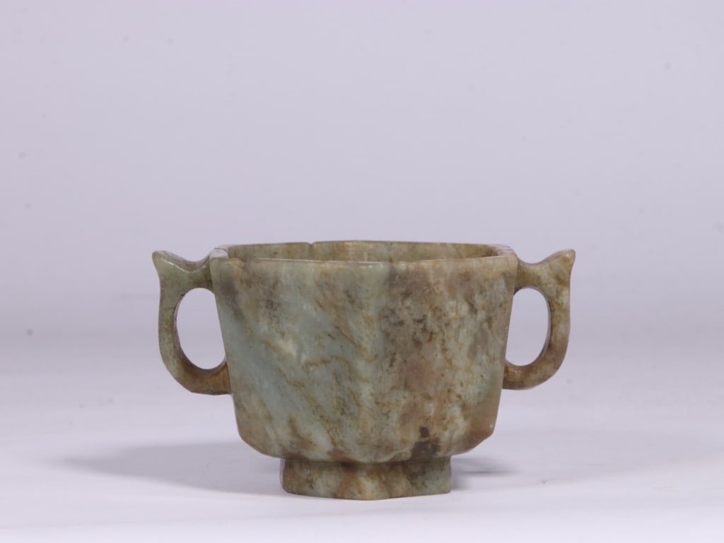Chinese Hexagonal shape Two-handled Jade Cup: The cup features deep, slightly flaring walls that taper down to a distinct, raised foot rim. Dimension : 6.2Cm H x 10cm L x 8.6cm,weight is 186gram. Flanking the sides are two symmetrical loop