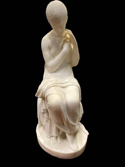 Alabaster Sculpture of a seated classical maiden: Dimension : 27 1/2"H. This sculpture depicts a seated classical maiden rendered in white marble or alabaster in the Neoclassical taste. The female figure is shown in a contemplative pose, seated upon