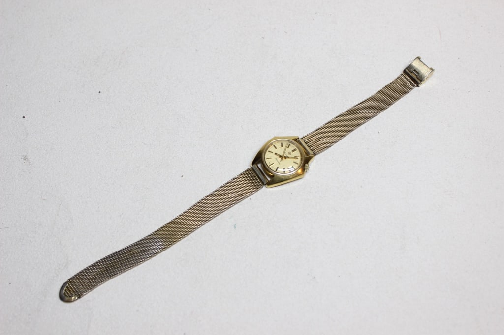 vintage Seiko ladies' automatic wristwatch: vintage Seiko ladies' automatic wristwatch, most likely from the Hi-Beat series produced in the late 1960s to mid-1970s. The dial Features a brushed champagne or gold-toned dial with a day-date