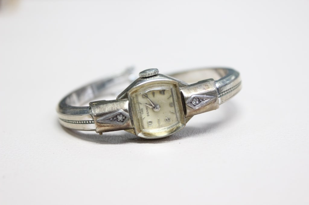 vintage Benrus ladies' wristwatch,: vintage Benrus ladies' wristwatch, likely dating from the 1950s. Characterized by an Art Deco aesthetic, it has fancy lug designs. The dial face is rectangular, featuring silver or