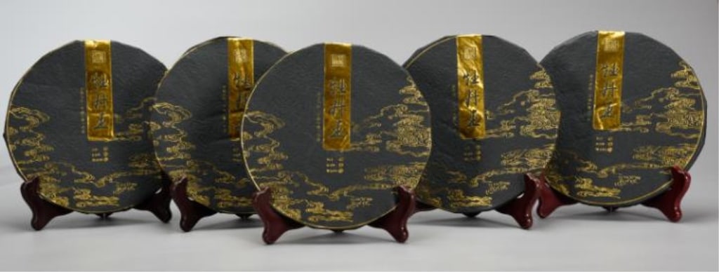 2018 Five premium Pu-erh tea cakes (Bingcha): five premium Pu-erh tea cakes (Bingcha) Dimension : 150gx5cakes. Each tea cake is meticulously wrapped in dark charcoal-grey textured paper, heavily adorned with elegant gold-foil clouds running