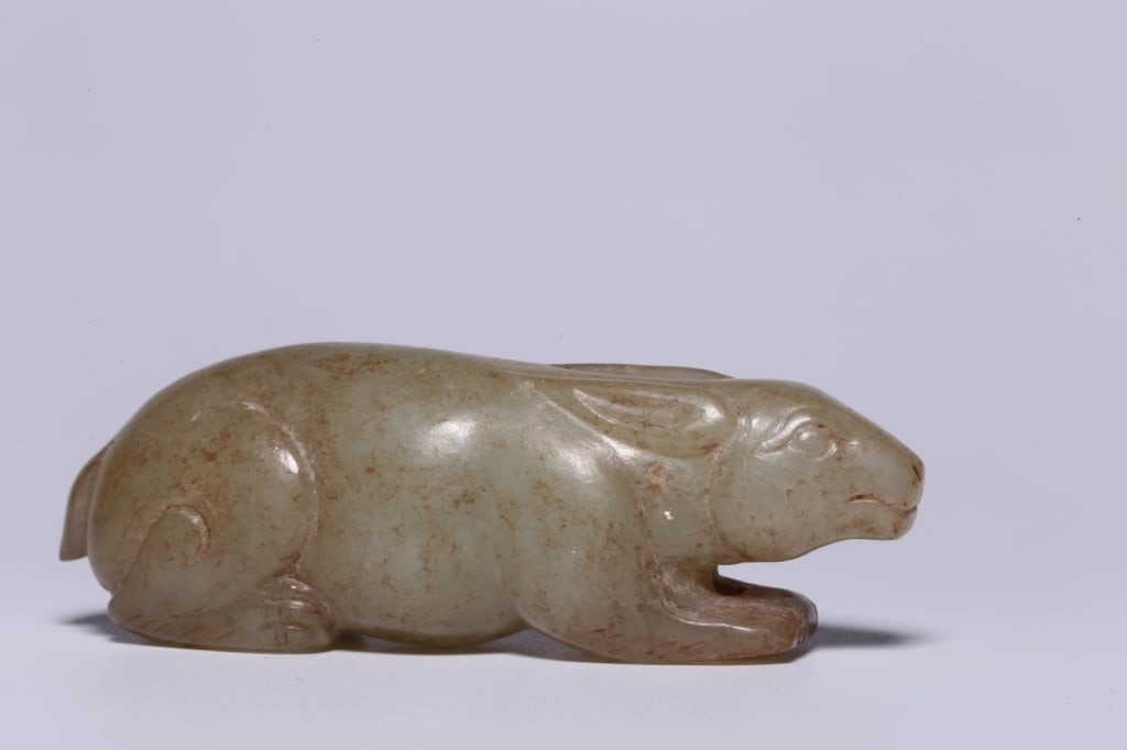 Chinese jade carving of a crouching rabbit: Dimension : 5.9cm L x 1.7 x 2cm,weight is 30.8gram. The rabbit is depicted in a recumbent, alert posture with its front paws extended forward and