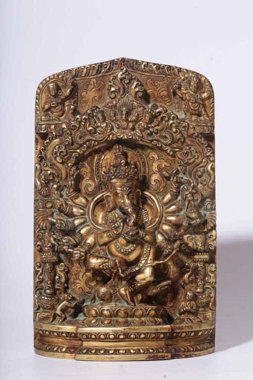 Himalayan gilt-bronze Plaque: Himalayan gilt-bronze plaque or stele depicting the multi-armed elephant-headed deity Ganesha Dimension : 19.5cm H x 11.5cm Lx 5cm. Ganesha is sculpted in a dynamic, active posture balanced atop a